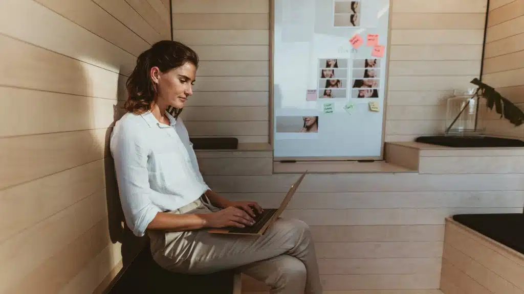 Businesswoman sitting in creative office working on laptop. Female executive using laptop computer in office.
